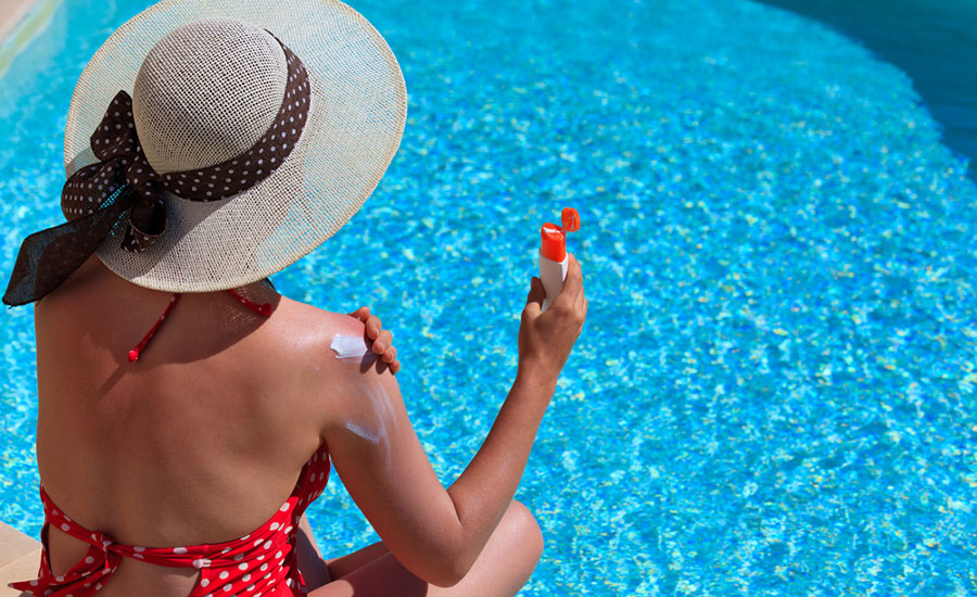 woman applying sunscreen to shoulder